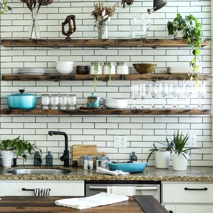 Kitchen with open shelving with organized plates, cups and bowls displayed